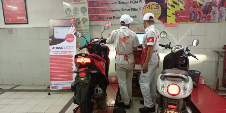 Dua Mekanik AHASS Honda Agung Motor tengah fokus pantau monitor CPU terkoneksi ke motor Honda