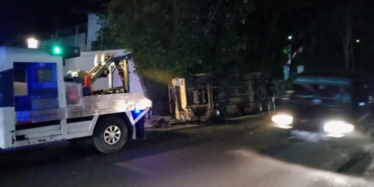 Pihak kepolisian Polres Cianjur mengevakuasi truk yang terguling di jalur puncak.